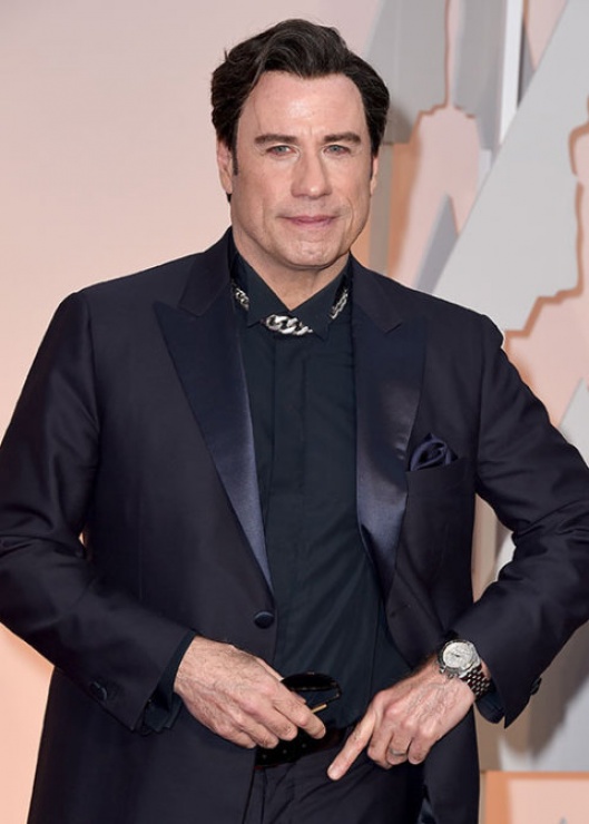 John Travolta sustituyó el clásico smoking por este traje brillante de color berenjena.